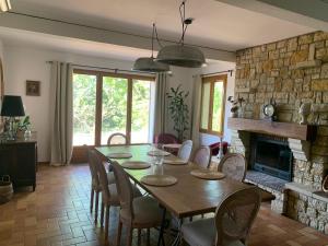 a dining room with a table and a fireplace at Villa Sainte BARBE in Loriol-du-Comtat