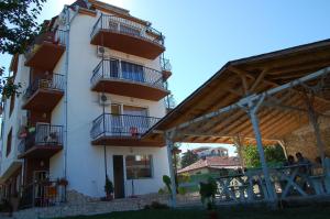 un gran edificio blanco con balcones en un lateral. en Apartments Ivelin, en Lozenets
