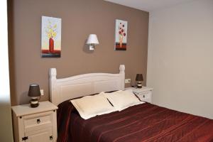 a bedroom with a white bed and two night stands at Los Palacios in Albarracín