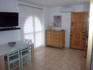 ein Esszimmer mit einem Tisch, einer Kommode und einem Fernseher in der Unterkunft Apartamento rural Casa Medico in Turre