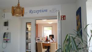 a woman sitting at a desk in an office at Hotel Dorfkrug Büsum in Büsum