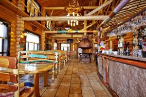 a restaurant with a bar with tables and chairs at Carivka Hotel in Tsarivka