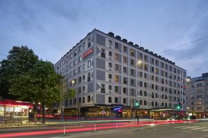 a large gray building on a city street at night at Scandic Malmen in Stockholm