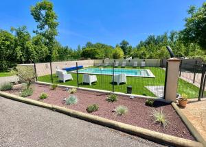 a backyard with a pool and chairs and a fence at " Ô Chai Nous " 14 pers - Billard, Babyfoot - Structure de Jeux in Poucharramet