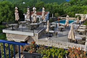 a restaurant with tables and umbrellas next to a pool at Boutique hotel Ruzmarin SPA & Garden by Aycon in Budva