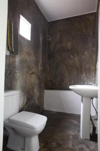 a bathroom with a toilet and a sink at Surf & Turf in Arugam Bay