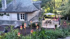a house with a garden with a table and an umbrella at Domaine Le Mayne in Chabrignac