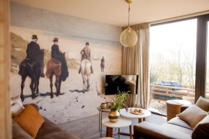 a living room with a painting of horses on the wall at Ecohome Bries 8personen en baby Zeezand Recreatie in 't Zand