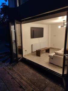 a living room with a couch and a flat screen tv at 4 Guests - Bbq - Parking - Garden in Bolton