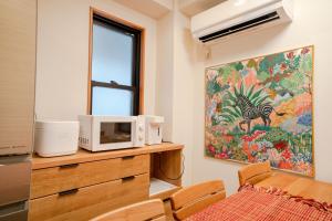 a kitchen with a microwave on a wooden dresser at 6 minutes walk from Yoyogi Station Close to Shinjuku 4-story detached house 110 square meters 3 bedrooms can accommodate up to 8 people Close to Shinjuku Takashimaya and Isetan in Tokyo