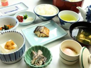 a table with bowls and plates of food at Ryokan Kamomeso in Sado