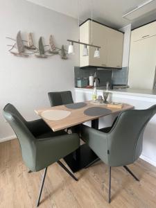 eine Küche mit einem Holztisch und zwei Stühlen in der Unterkunft "Haus Atlantic" - Wohnung "StrandGut" in Grömitz