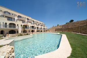 a swimming pool in front of a building at Serene Apt with Terrace & Pool & BBQ Access,Qala by 360 Estates in Qala +45 photos