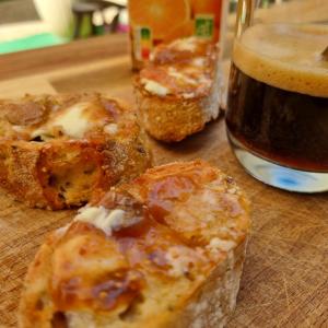 a wooden table with two pieces of bread and a bottle of beer at La Bulle Carrée - Centre Historique médiéval - in Lapalme +26 photos