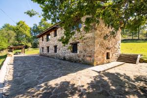 ein Steingebäude mit einer Bank davor in der Unterkunft Cabaña Pasiega El Ojal in San Pedro del Romeral