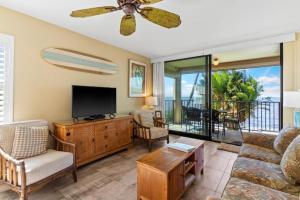 a living room with a flat screen tv and a couch at KIHEI BEACH, #210 condo in Kihei