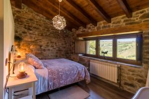 ein Schlafzimmer mit einem Bett und einem Fenster in der Unterkunft Cabaña Pasiega El Ojal in San Pedro del Romeral