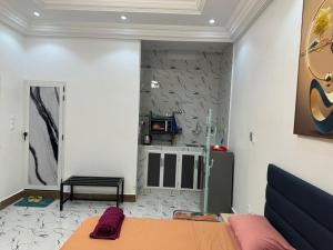 a bedroom with a bed and a stone wall at Tinou Apparts zac Mbao in Dakar