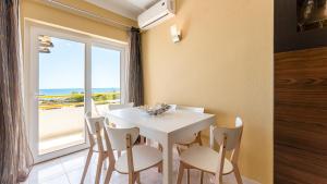 a dining room with a white table and chairs and a window at Star Paradise in Armação de Pêra
