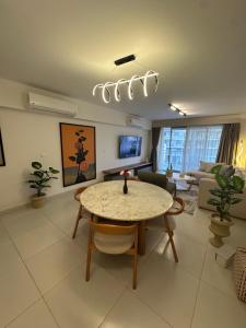 ein Wohnzimmer mit einem Tisch und einem Sofa in der Unterkunft Marassi 2-bed Marina Views Sandy Lagoon in El-Alamein