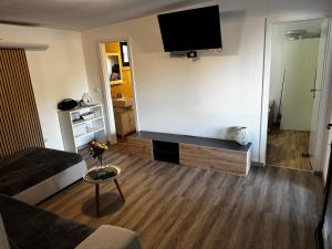 a living room with a couch and a tv on the wall at Beach house Chris in Pakoštane