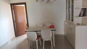 a dining room table with white chairs and a mirror at Roadshow housing apartment budhanilkantha in Bākhri Kharka