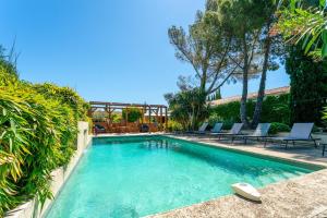 a swimming pool with chairs in a yard at Charmante Villa avec piscine in Fontvieille