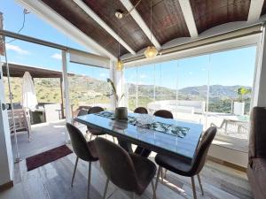 a dining room with a glass table and chairs at Cortijo Los Matías in Sayalonga