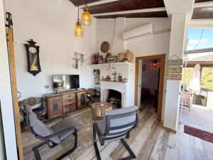 a living room with two chairs and a fireplace at Cortijo Los Matías in Sayalonga