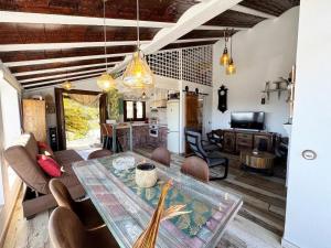 a dining room with a table and a living room at Cortijo Los Matías in Sayalonga