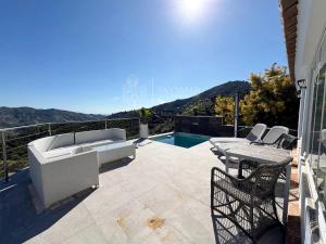 a patio with a couch and a table and chairs at Cortijo Los Matías in Sayalonga