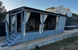 a blue house with curtains on the porch at Beach house Chris in Pakoštane