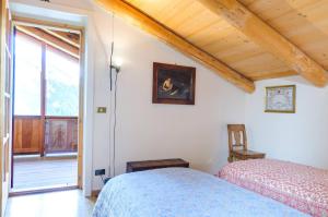 a bedroom with two beds and a large window at Chalet Monciòn in Rualp