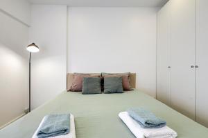 une chambre avec un lit avec deux serviettes dessus dans l'établissement Casa Baleeira - Modern apartment with Seaview, à Armação de Pêra 30 autres photos