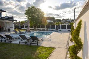 a backyard with a pool with chairs and a table at Villa Hanna Ilidža in Kamenjača