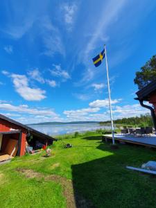 a flag on a yard with a view of the water at Camp Caroli Hobbit Hut in Jukkasjärvi +16 photos