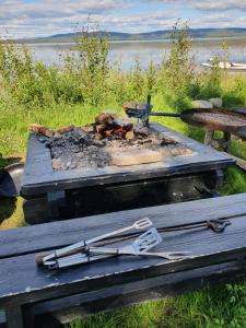 a picnic table with a grill and tools on it at Camp Caroli Hobbit Hut in Jukkasjärvi