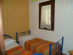 ein kleines Zimmer mit 2 Betten und einem Fenster in der Unterkunft Acqua Marina in Custonaci