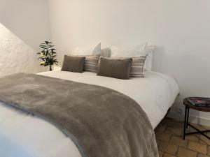 a bedroom with a large white bed with pillows at Domaine la Boulinière - Le Faisan in Journet