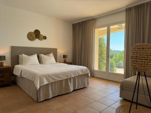 Un dormitorio con una cama y una puerta corrediza de vidrio. en La Villa Belvédère, en Le Lavandou 26 fotos más