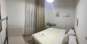 a white bedroom with a bed and a light at Apartman Antony in Čitluk