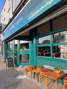 ein Restaurant mit Holzbänken vor einem Gebäude in der Unterkunft Charming1 bed flat in Hastings