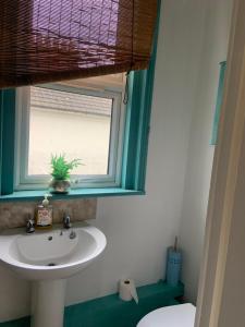 ein Badezimmer mit Waschbecken und Fenster in der Unterkunft Charming1 bed flat in Hastings