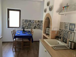 a kitchen with a table with a blue table cloth at Káli-lak Vendégház in Köveskál