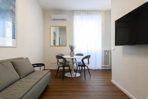 Una sala de estar con un sofá y una mesa con sillas. en Civico7 - Luxury Apartment, en Roma