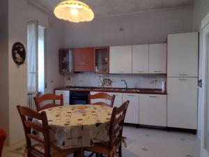 a kitchen with a table and a kitchen with white cabinets at Le Rondini in Trani +19 photos