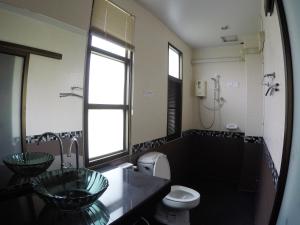 a bathroom with two sinks and a toilet at The Old Palace Resort Klong Sa Bua in Phra Nakhon Si Ayutthaya