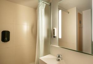 a bathroom with a sink and a mirror at B&B HOTEL Saint-Nazaire Trignac in Trignac +35 photos