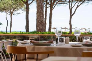 a table with chairs and wine glasses on a patio at Grand Hôtel Du Lido - sur la plage d'Argèles in Argelès-sur-Mer