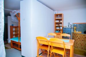 a dining room with a table and chairs and a kitchen at Aika Sunrise - Your Home in the Hills in Iringa +62 photos